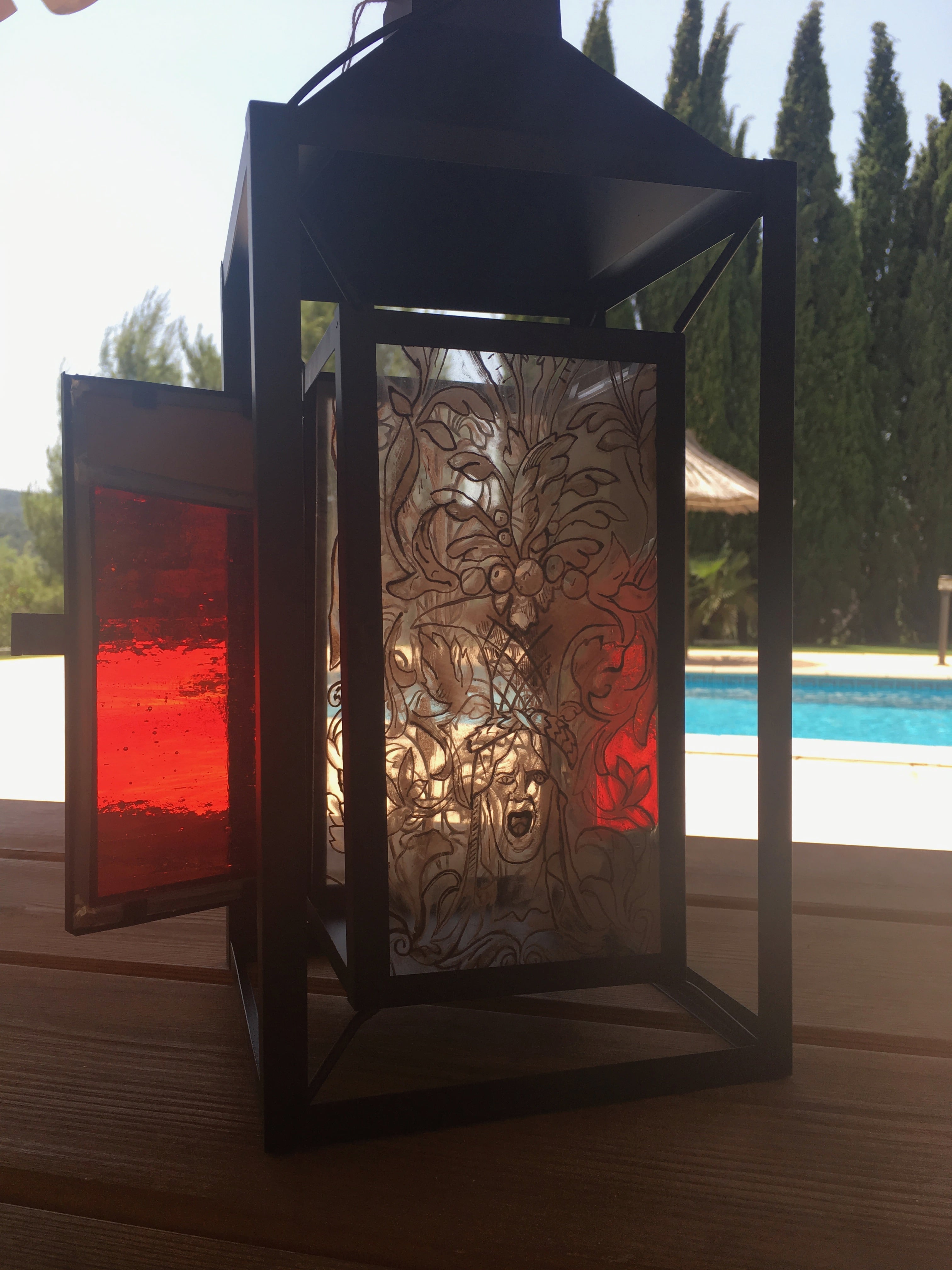 Lanterne en métal noir, verres rouges et transparents avec motif figuratif, 60€